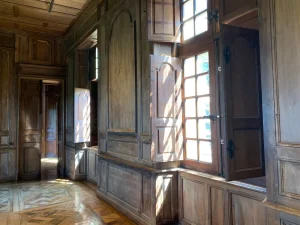 Chambre du Château du Creux au lever du jour, murs en pierre et parquet anciens